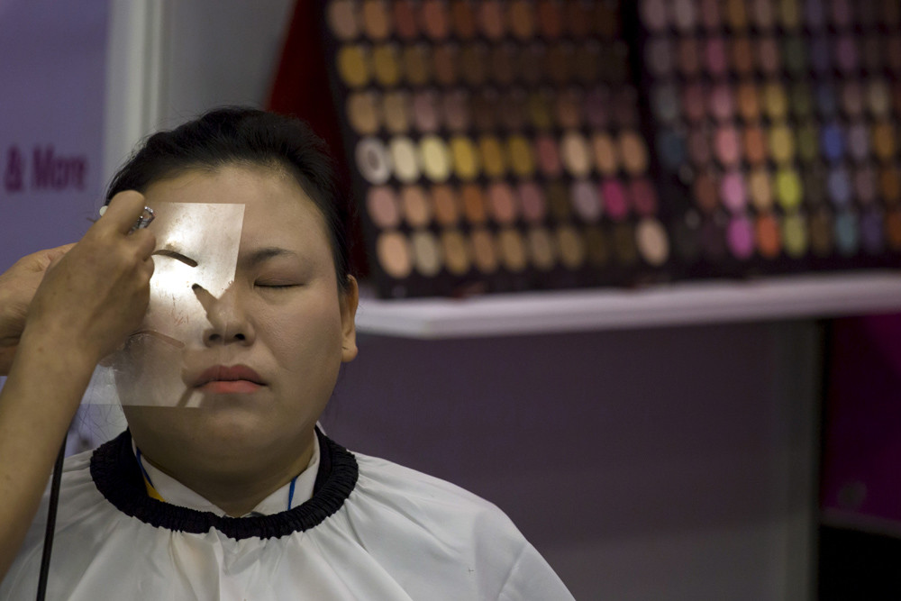Een make-updemonstratie op de Aziatische Uitvaart- en Begrafenisbeurs in Macau. © Tyrone Siu / Reuters