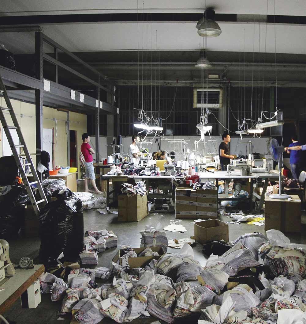 Chinese arbeiders in een in beslag genomen illegale textielfabriek in Prato, in de buurt van Florence.  © Fabrizio Giovannozzi /  AP Photo