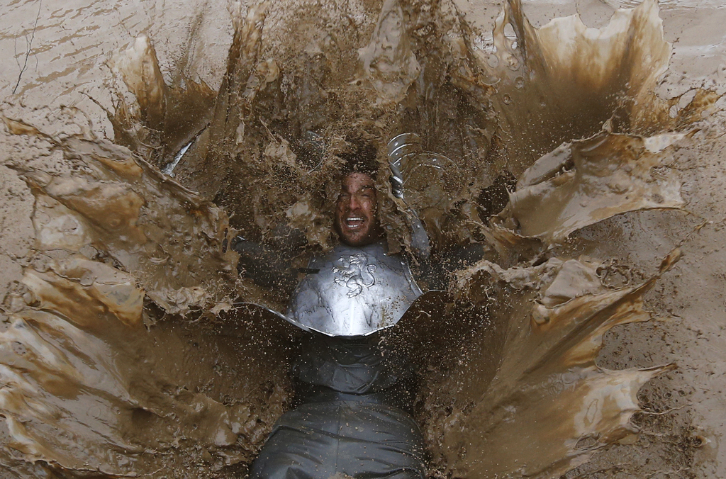 Een deelnemer aan de Tough Guy event in Perton, Engeland. Elk jaar vechten duizenden mannen en vrouwen tegen de elementen. Koude modder, prikkeldraad, elektrische schokken en kilometers afzien voor een goed doel. – © Darren Staples / Reuters