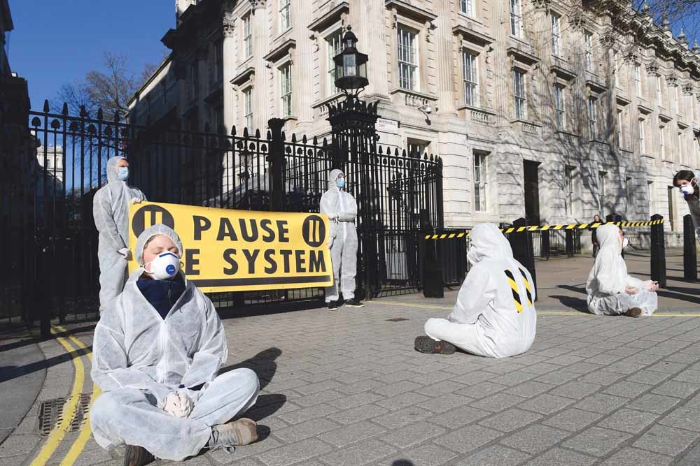 Een groep activisten protesteert voor Downing Street 10 tegen het coronabeleid van premier Johnson. – © Unsplash