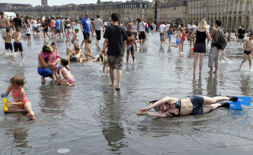 Mensen genieten van het mooie weer op de place de la Bourse in het centrum van Bordeaux. – © Regis Duvignau / Reuters 
