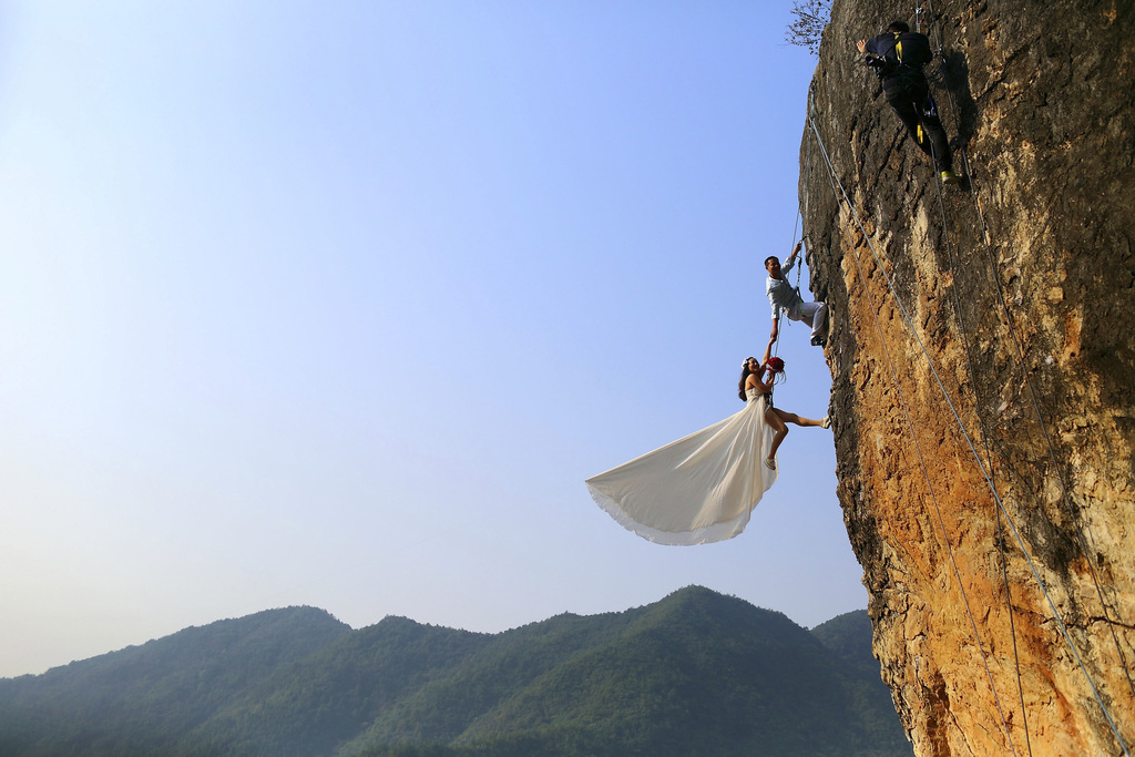 Amateurbergbeklimmer Zheng Feng neemt trouwfoto’s met zijn vrouw op een klif in Jinhua. Foto: China Daily