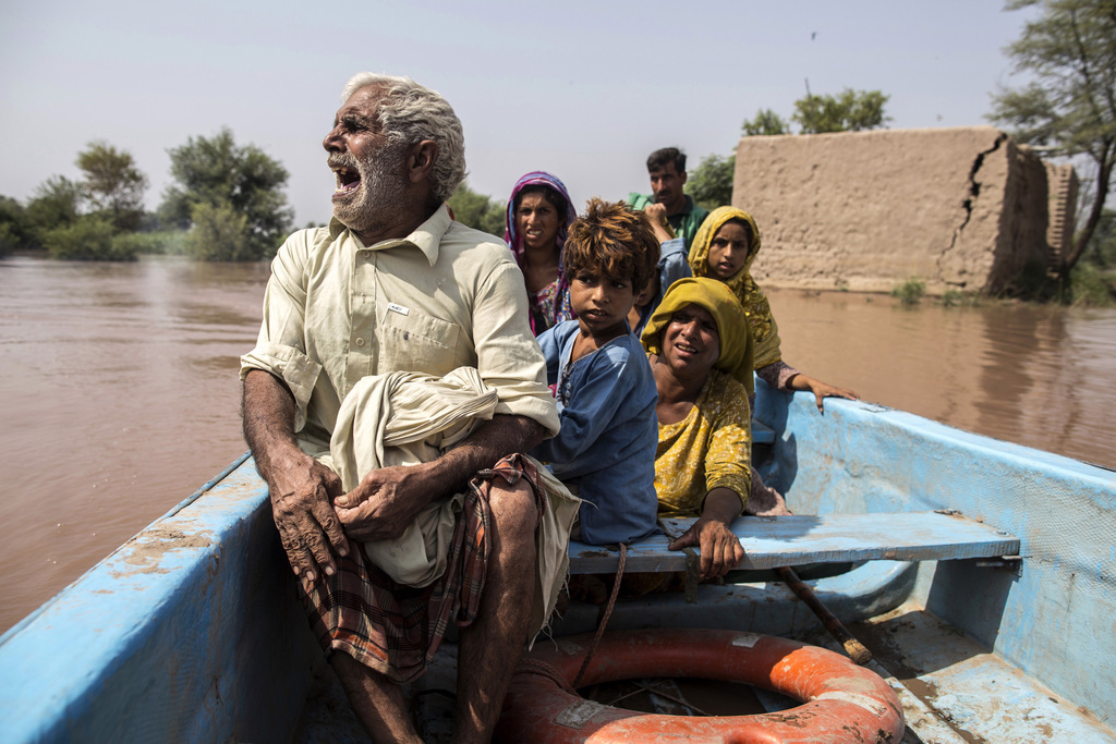 Een slachtoffer van de overstromingen in de Indiase provincie Punjab praat met familieleden tijdens zijn evacuatie. Ten gevolge van de zware regenval kwamen 450 mensen in India en Pakistan om het leven. Foto: Zohra Bensemra/Reuters