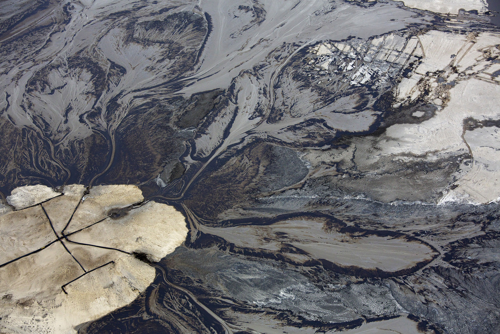 Olie stroomt in een residubekken op teerzanden van de Canadese oliemaatschappi Suncor in de buurt van Fort McMurray, Alberta. Succor is een pionier op het gebied van oliewinning uit teerzanden. Foto: Todd Korol/Reuters